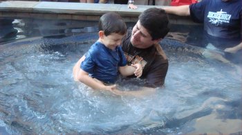 Riley being baptized by his daddy